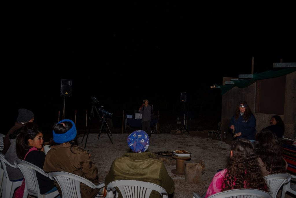 Grupo reunido de noche junto al telescopio