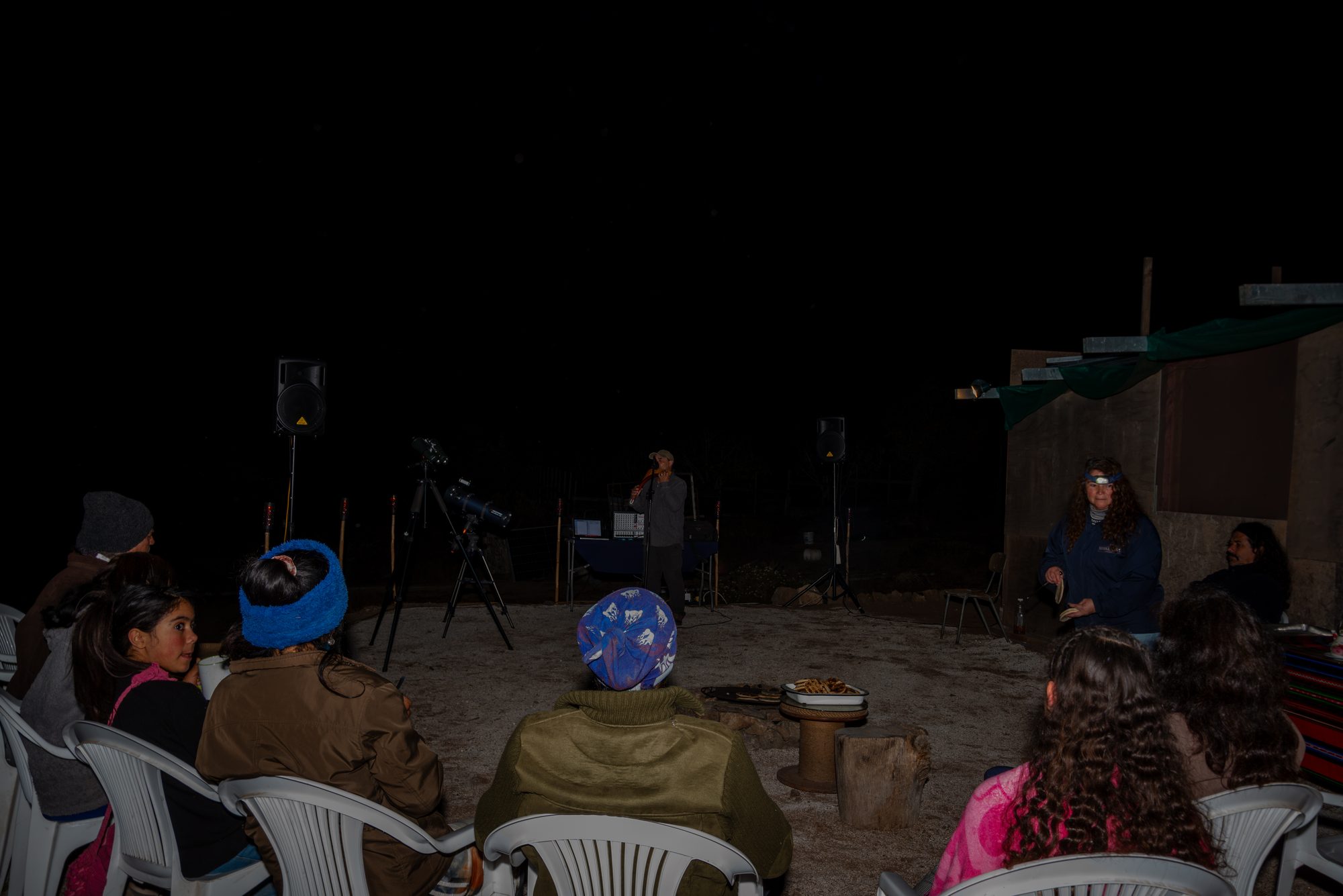 Grupo reunido de noche junto al telescopio